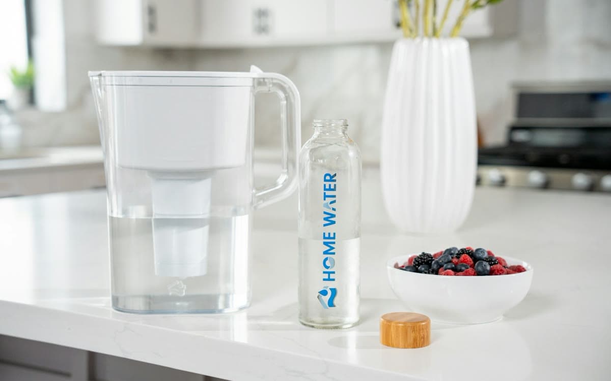 A HomeWater pitcher and bottle on a kitchen counter.